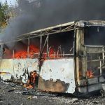 Ônibus danificado em área de conflito.